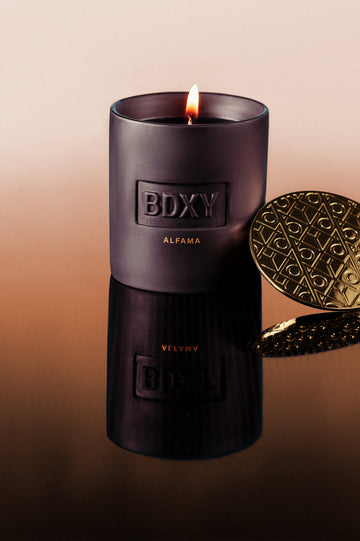 Black candle with 'BDXY' branding on a gradient background
